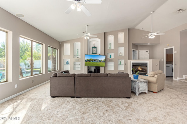 living room featuring light carpet, lofted ceiling, ceiling fan, and separate washer and dryer