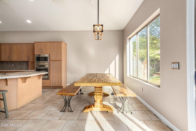 tiled dining space featuring a healthy amount of sunlight