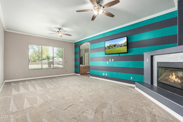 unfurnished living room featuring ornamental molding, ceiling fan, and carpet floors