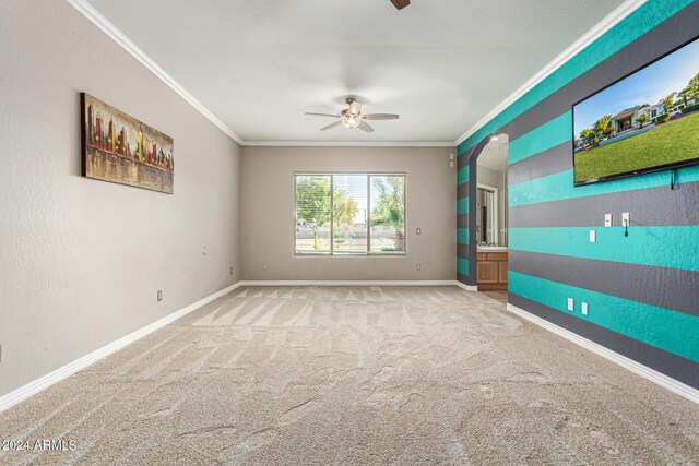 carpeted spare room with ceiling fan and crown molding