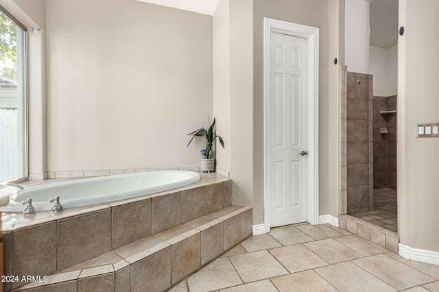 bathroom with separate shower and tub and tile patterned flooring