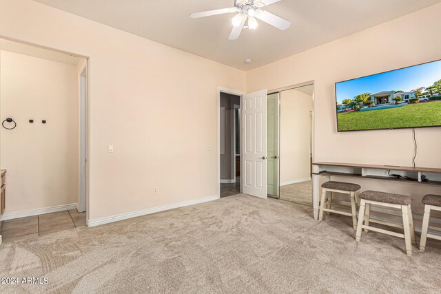 interior space featuring ceiling fan and light colored carpet