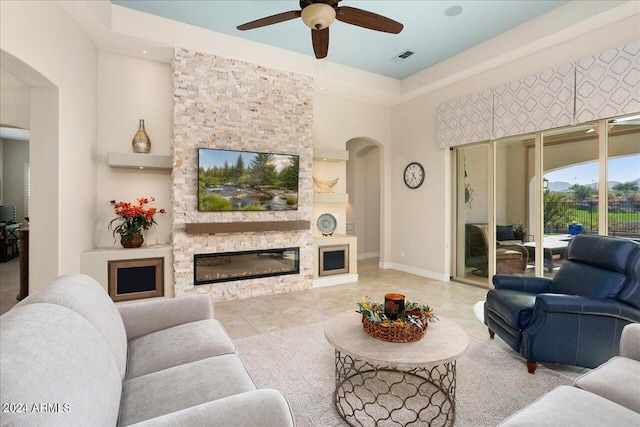 living room featuring ceiling fan and a fireplace