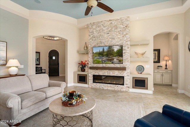 living room with ceiling fan and a fireplace