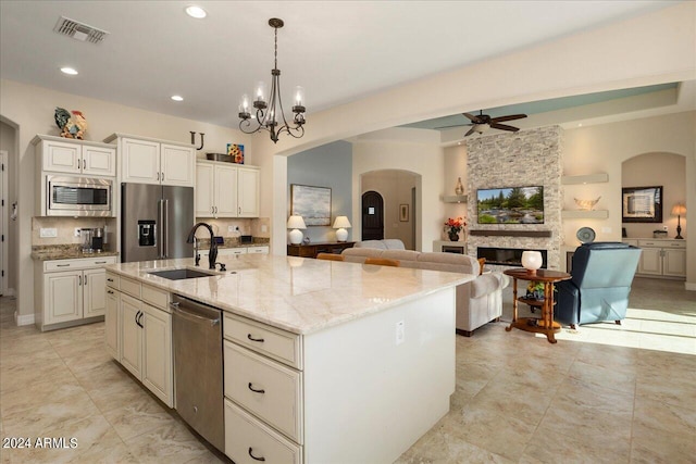 kitchen with decorative light fixtures, an island with sink, stainless steel appliances, and sink