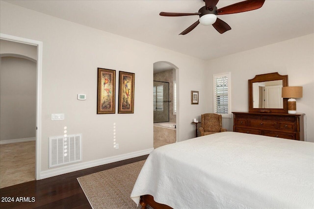 bedroom with ensuite bathroom, ceiling fan, and dark wood-type flooring