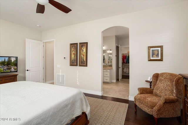 bedroom with ceiling fan, hardwood / wood-style floors, a spacious closet, a closet, and ensuite bath