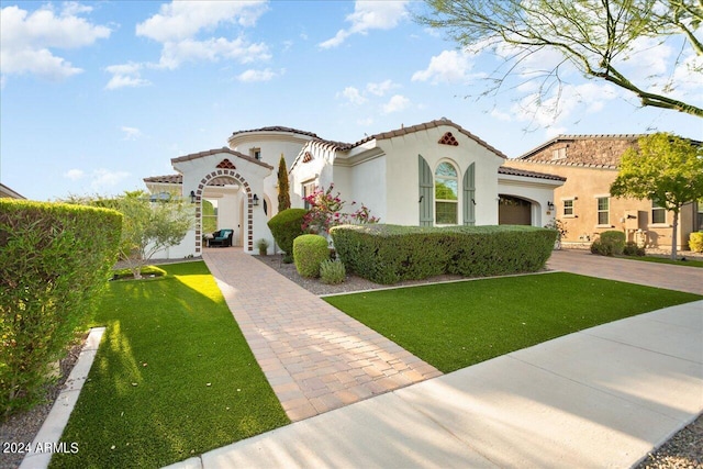 mediterranean / spanish-style home with a garage and a front yard