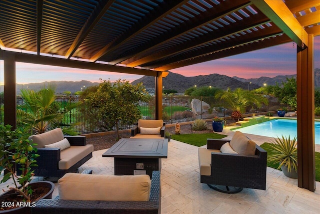 patio terrace at dusk with outdoor lounge area, a pergola, a mountain view, and a fenced in pool