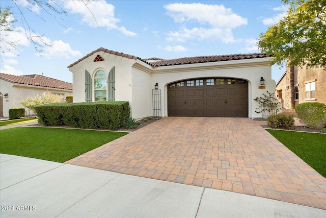 mediterranean / spanish home with a front yard and a garage