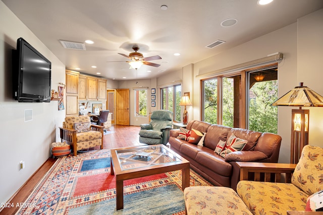 living room with light hardwood / wood-style flooring and ceiling fan