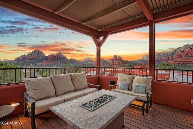 deck at dusk with a mountain view and an outdoor living space with a fire pit