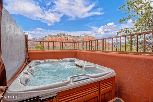 view of patio with a hot tub and a mountain view