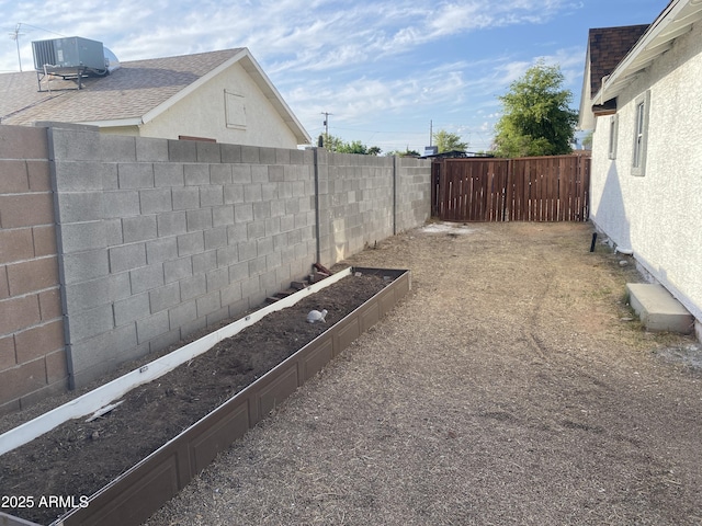 fenced backyard featuring central air condition unit