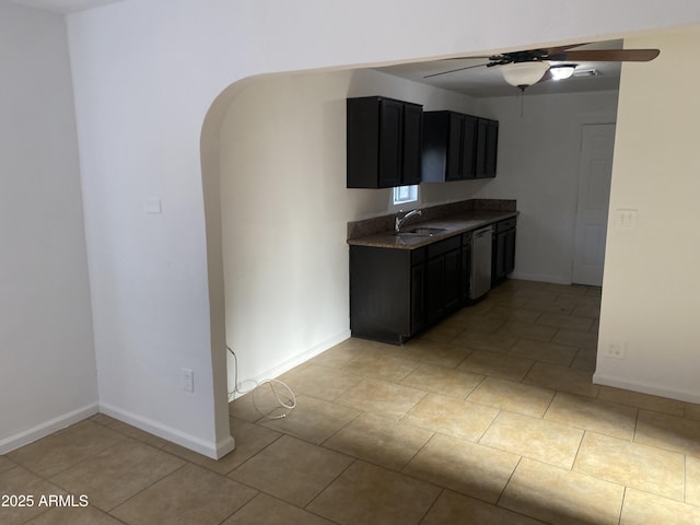 kitchen featuring dishwasher, a ceiling fan, a sink, arched walkways, and baseboards