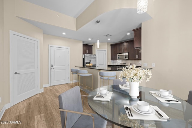 dining area featuring recessed lighting, baseboards, light wood-type flooring, and visible vents