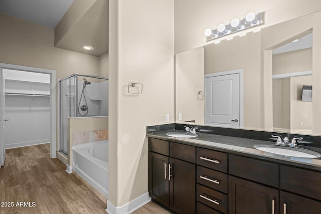 full bathroom featuring a shower stall, a sink, and wood finished floors