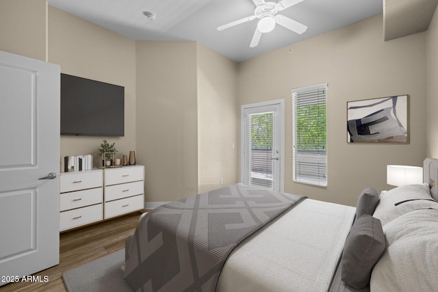 bedroom featuring a ceiling fan, wood finished floors, and access to exterior