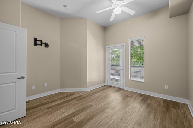 empty room featuring baseboards, ceiling fan, and wood finished floors