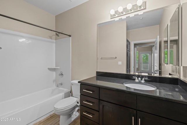 full bath featuring vanity, shower / bath combination, wood finished floors, and toilet