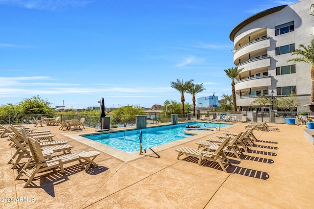community pool with fence and a patio