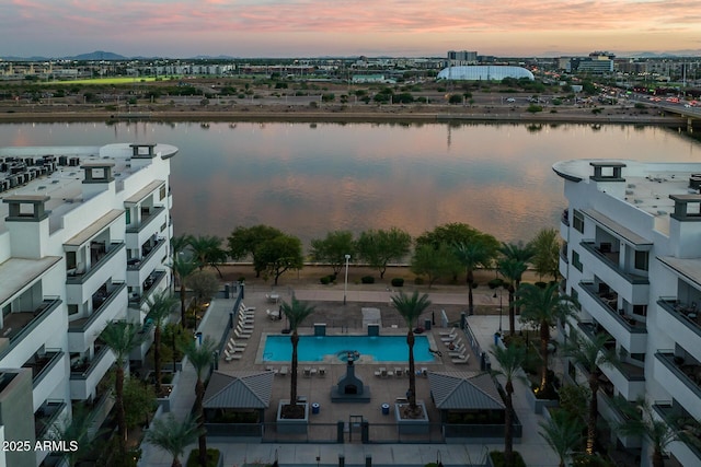 aerial view at dusk featuring a water view