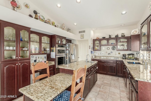 kitchen featuring stainless steel appliances, glass insert cabinets, and a center island