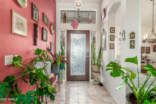 entrance foyer featuring baseboards and an inviting chandelier