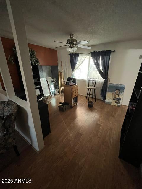 interior space featuring hardwood / wood-style floors, a textured ceiling, and ceiling fan