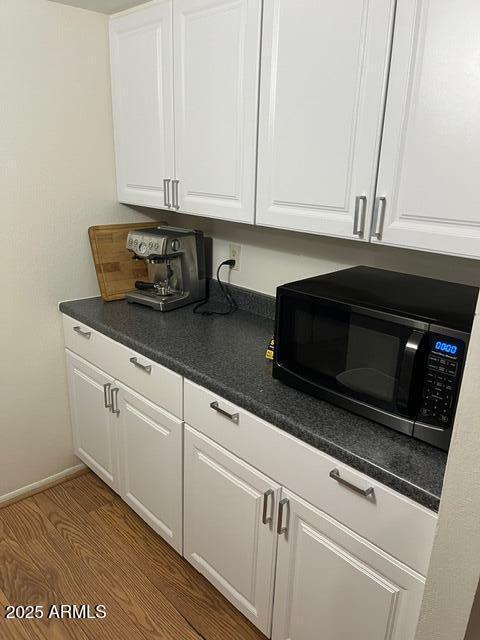 kitchen featuring white cabinetry and hardwood / wood-style floors