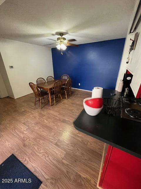 dining room featuring hardwood / wood-style flooring, ceiling fan, and a textured ceiling