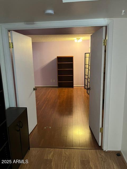 corridor with hardwood / wood-style flooring