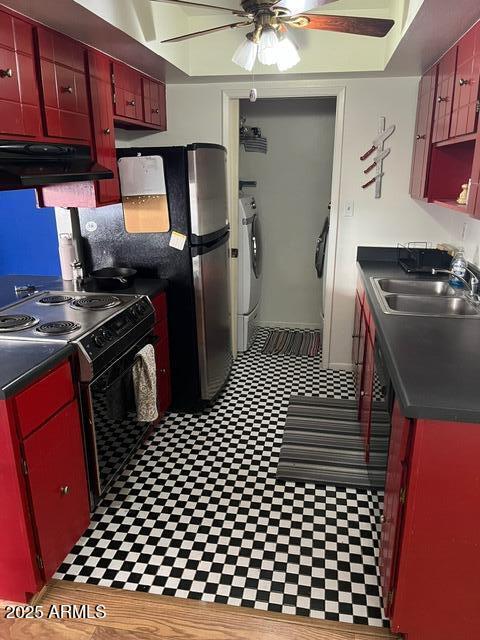 kitchen with electric range oven, washing machine and dryer, sink, and ceiling fan