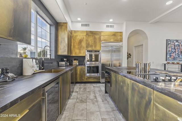 kitchen with sink, beverage cooler, and appliances with stainless steel finishes