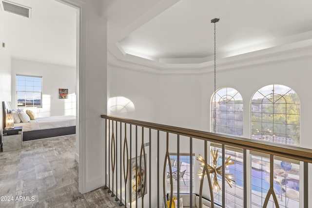 corridor featuring a tray ceiling and wood-type flooring