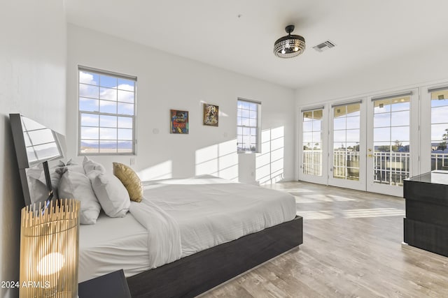 bedroom with light wood-type flooring, access to outside, and french doors