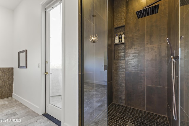 bathroom featuring a tile shower and wood-type flooring