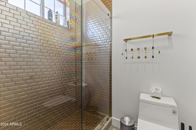 bathroom with toilet and a shower with door