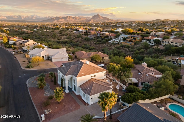 aerial view at dusk featuring a mountain view