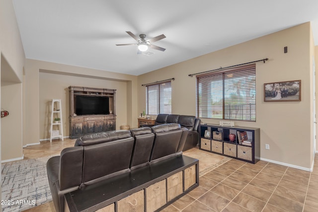 living room with light tile patterned floors, baseboards, and ceiling fan