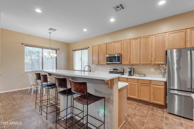 kitchen featuring stainless steel appliances, visible vents, and light brown cabinetry