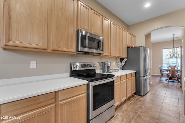 kitchen with arched walkways, light brown cabinetry, and stainless steel appliances