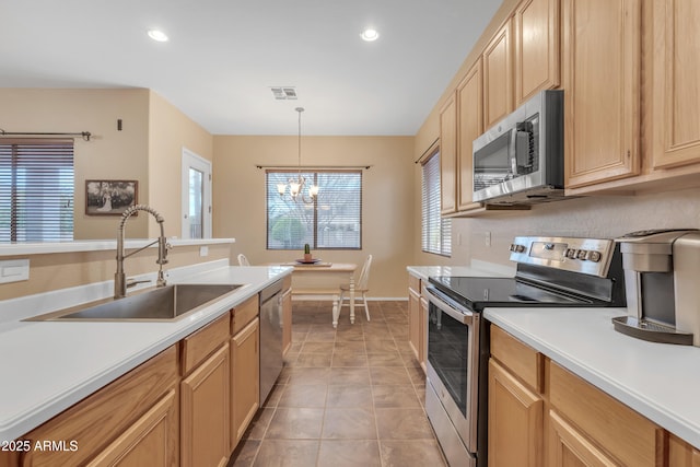 kitchen with visible vents, light countertops, a notable chandelier, stainless steel appliances, and a sink