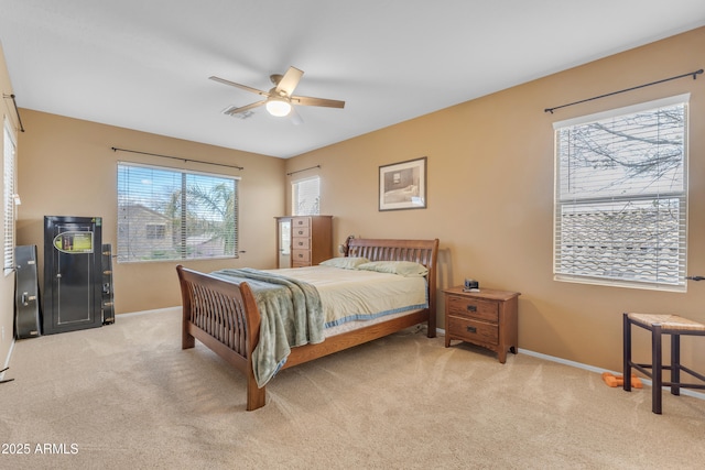 bedroom with light carpet, ceiling fan, and baseboards