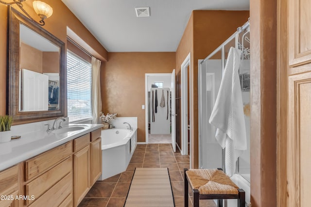 bathroom with visible vents, a garden tub, a stall shower, tile patterned flooring, and vanity