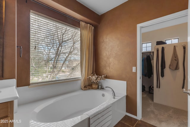 full bathroom featuring vanity, a garden tub, and tile patterned flooring