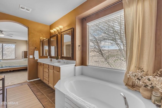 ensuite bathroom with visible vents, a garden tub, ensuite bathroom, a sink, and double vanity