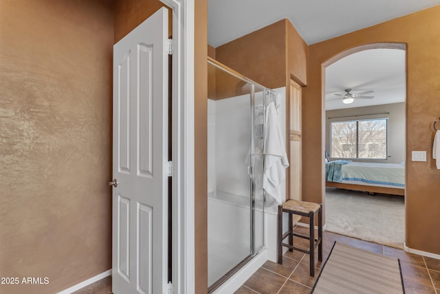 bathroom featuring a stall shower, baseboards, ensuite bath, and ceiling fan