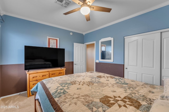 carpeted bedroom with a ceiling fan, visible vents, a closet, and ornamental molding