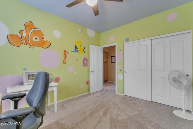 carpeted home office featuring baseboards and ceiling fan